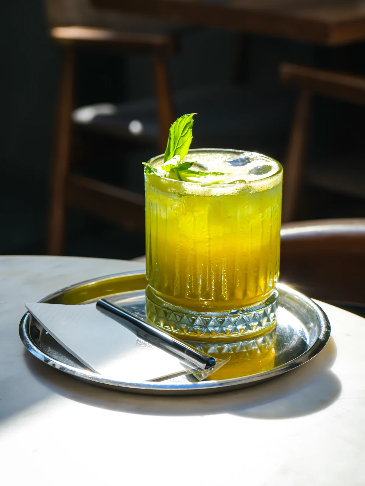 Le Petit Moulin'de buzlu limonata: taze nane yaprağıyla süslenmiş, gümüş tepside servis edilen soğuk içecek