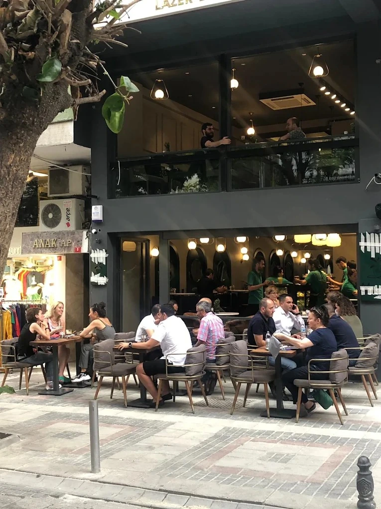 Le Petit Moulin'in Bakırköy Zeytinlik'teki Yakut Sokak cephesi: kaldırımdaki masalarda oturan misafirler ve iki katlı camlı cephe